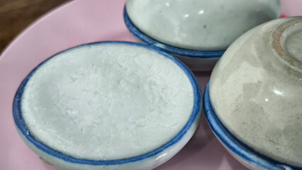 Thai dessert (khanom thuay) coconut milk custard in small porcelain cup .