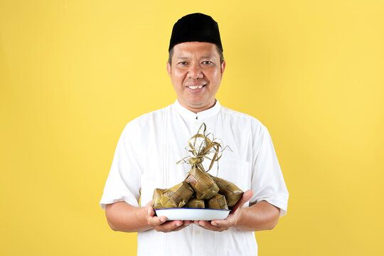Middle Age Asian Man Holding A Plat eof Ketupat Rice Cake for Lebaran Ied Al Fitr