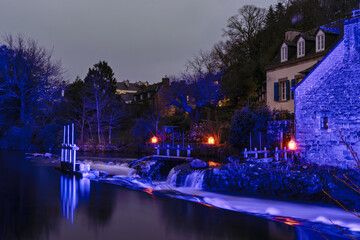 Une pose longue capture les reflets scintillants des illuminations de No&euml;l sur l&rsquo;Aven, transformant la rivi&egrave;re en un tableau lumineux et f&eacute;&eacute;rique.