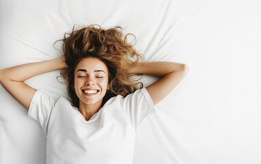 Naklejka premium Happy young woman relaxing on a bed with white sheets, enjoying a moment of tranquility and joy in a bright room