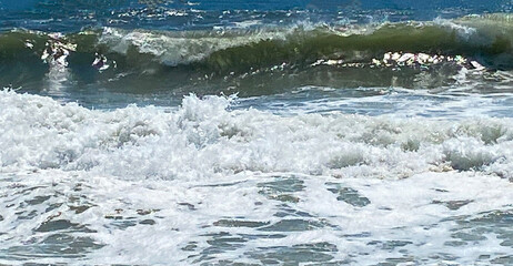 Waves Crash Onto the Shore at a Sunny Beach During Afternoon Hours