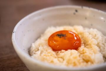 A bowl of Japanese rice with pickled egg yolk on top