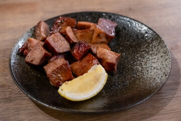 Grilled beef tongue served on plate with lemon