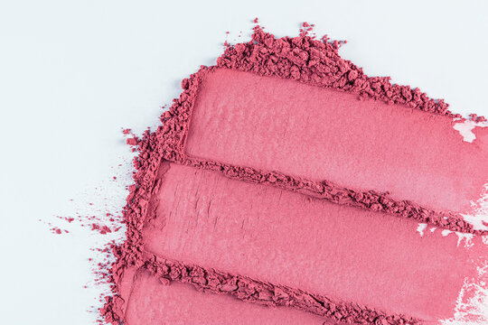 Three chic samples of pink blush on a white background. parallel strokes of loose dry blush. top view. A copy space. texture of cosmetics. close up.