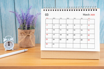 March Monthly desk calendar for 2025 year and alarm clock.