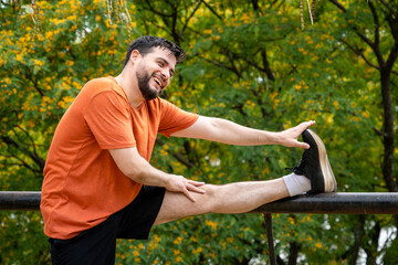 Hombre haciendo estiramientos de piernas luego de su entrenamiento al aire libre en el Parque de su ciudad