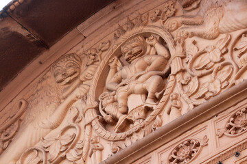 Hindu God Nrisimha tears apart the demon Hiranya Kashipu. Fragment of decorative molding on the wall of a Hindu temple in India.