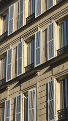 Obraz premium Gros plan sur des volets blancs ouverts d’un immeuble haussmannien.