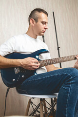 Obraz premium Musician, guitarist or man studying at home for performance practice, hobby or solo track with talent. Man playing an electric guitar at home