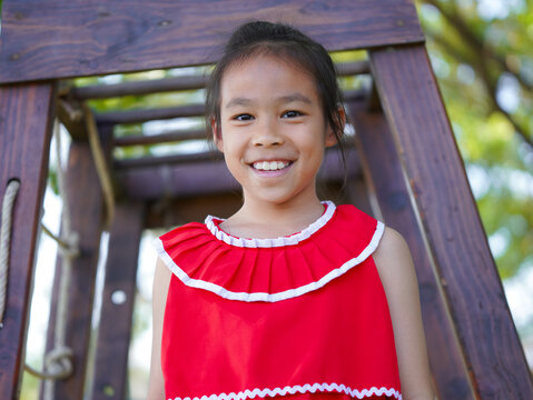 Cute girl playing in the playground during summer vacation. Happy children having fun in an outdoor park.