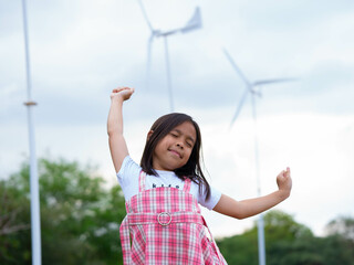 A happy little girl with arms outstretched breathing fresh air enjoying nature in the morning.