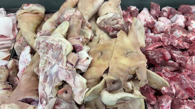Pig head raw meat for sale on shelf at supermarket.
