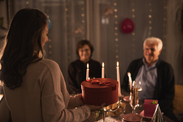 Granddaughter Presenting Gift to Happy Family