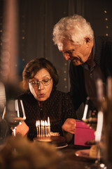 Elder Woman Blows Out Candles