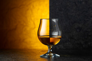 Glass of brandy on a black table.