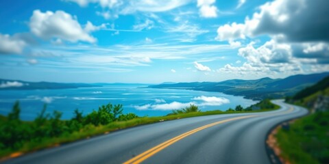 Scenic Coastal Highway Winding Through Lush Green Landscape Under a Blue Sky with Puffy Clouds