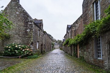 Les ruelles pavées de Locronan après la pluie, les maisons en pierre semblent endormies sous un...