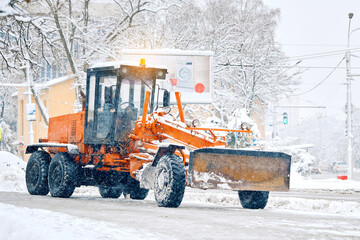 Snow removal grader clearing icy sidewalks and city roads during winter, cleaning pathways during...