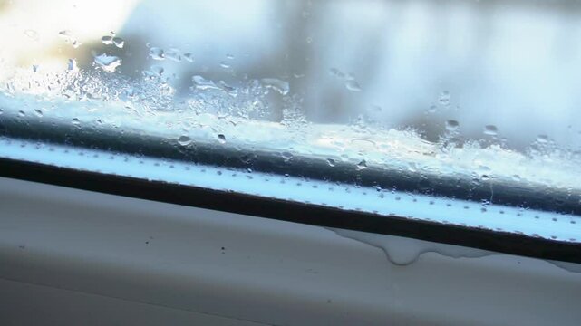 Foggy and damp window in the apartment, condensation on the plastic window