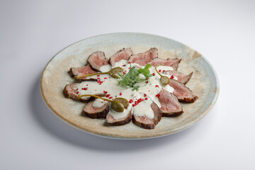 A beautifully arranged plate of meat and sauce on a table