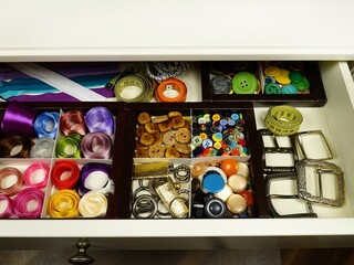 Desk drawer with clothing accessories for sewing and needlework, organizing and storing things in the house. 