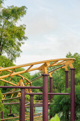 A thrilling view of a roller coaster track winding through the vibrant atmosphere of an amusement park. The photo captures the dramatic curves and loops of the steel structure against a bright, cheerf