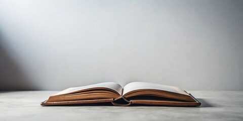 Open book with aged pages resting on a table against a neutral backdrop