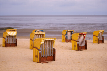 Leere Strandkörbe am Meer bei Ebbe