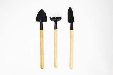 Gardening tools on white background: shovels and rakes. Top view. Copy space.