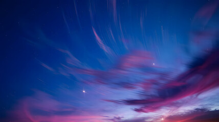 A photo of a night sky with swirling patterns of deep blue, purple, and pink hues.