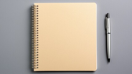 Stationary setup beige notebook and pen on grey background