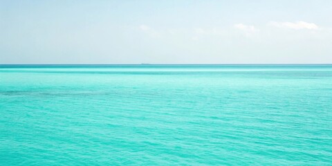 Obraz premium A serene view of the tranquil ocean, with its vibrant turquoise hues and gentle waves, stretching out towards a distant horizon