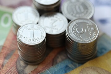 Few stacks of ukrainian money coins lies on old hryvnia banknotes