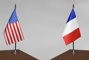 Table flags of USA and France on a gray blurred background