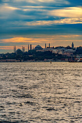 Naklejka premium view from a pleasure boat on the Bosphorus and the cityscape of Istanbul, Turkey, the architecture of the city at sunset, a popular tourist destination.
