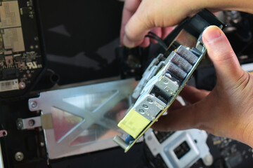Computer technician wearing a mask and goggles Dismantling computer equipment for repairs, replacing parts and making repairs on his table