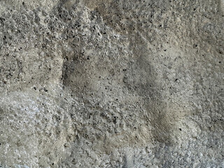 Close up of silver grey painted stone with rough and uneven texture, with some glitters for decoration purpose. Seamless background texture