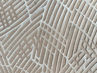 Close up of random curved fluted pattern made with porcelain ceramic tiles in abstract curves. Rough uneven surfaces of porcelain ceramic tiles seamless background texture. © TMR Studio