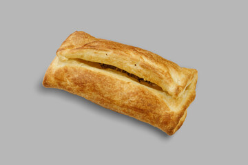 A delicious pastry featuring a slice cut out of it resting on a gray background