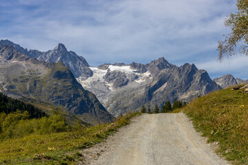Alps scenic landscape on Tour du Montblanc. Rocky and snow summit peaks of the Alps on the trekking route TMB around Mont Blanc in Chamonix and Courmayeur. Alpine scene with mountains and lakes 