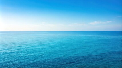 Fototapeta premium A vast expanse of blue ocean water under a clear sky with subtle white clouds