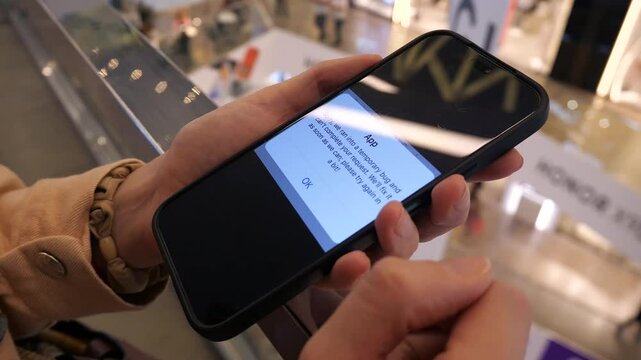 A phone in hands with an error message and the impossibility of completing a request on its screen. A notification about an error and that it will soon be fixed on the screen of a phone in hands