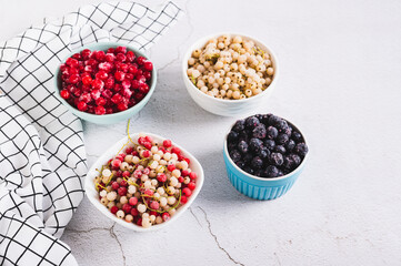 Frozen red, white, black currants and viburnum in cups on the table