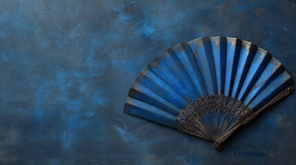 Decorative blue fan against a textured blue background highlighting intricate design details