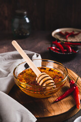 Hot honey chili sauce in bowl on table vertical view