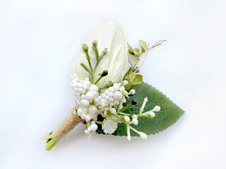 Close up of flower corsage brooch of white tulip, baby breath flowers, and green leaves, isolated...