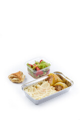 white background disposable plastic and foil tableware airplane food snack mashed potatoes and stuffed peppers vegetable salad dietary program daily allowance one-time meals