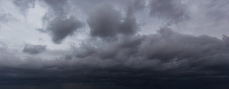 The dark sky filled with swirling clouds forebodes an approaching windstorm, showcasing the power of nature's forces and the dramatic shifts in weather during turbulent atmospheric conditions.