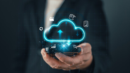 A businessman holds a smartphone with a glowing cloud icon, symbolizing cloud computing, data storage, digital solutions, and online technology for modern business and virtual connectivity