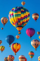 Fototapeta premium Colorful hot air balloons float above a vibrant crowd during a festival at dawn